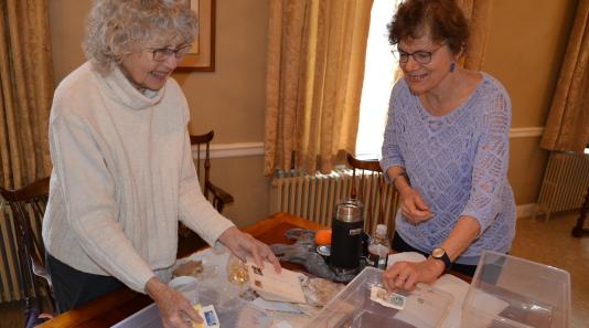 Linda Lee and Amy Perry of FFI sorting stamps